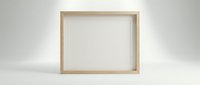 Empty wooden picture frame standing on white surface against neutral background for mockup and design projects.