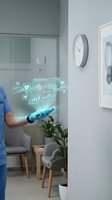 Doctor in blue scrubs holding glowing holographic health data display with heart rate, vital signs, and medical charts in modern clinic interior for telemedicine and healthcare technology.