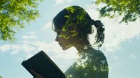 Young Asian woman reading book in nature with double exposure effect showing green tree leaves merging with her silhouette against bright sky background.