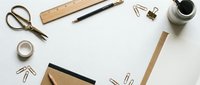 Flat lay office workspace with blank paper, vintage scissors, wooden ruler, fountain pen, paper clips, tape and coffee cup on white background for business design.