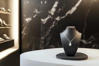 Elegant diamond pendant necklace on display bust against luxurious black marble background in upscale jewelry boutique setting.