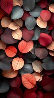 Colorful autumn leaves in shades of red, gray and peach creating natural pattern background. Seasonal foliage with detailed leaf veins and moody dark atmosphere.