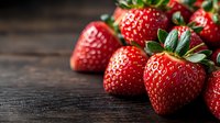 Fresh ripe strawberries with green leaves on dark wooden background, selective focus with copy space. For food packaging, menu design and marketing.