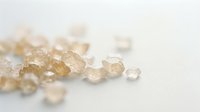 Scattered raw citrine quartz crystals and mineral stones isolated on white background for jewelry design and gemstone product photography.