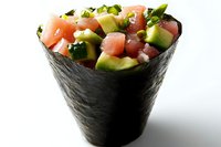 Fresh salmon and avocado temaki hand roll with cucumber and green onion wrapped in crisp nori seaweed against white background. Japanese cuisine.