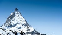Majestic snow-covered mountain peak against clear blue sky, alpine landscape for travel and nature projects.