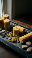 Beeswax candles arranged on black slate tray with natural stones and dried botanicals, creating a spa and wellness home decor display.