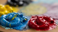 Vibrant acrylic paint colors mixed on artist palette with brush creating colorful artwork for creative projects and artistic expression.