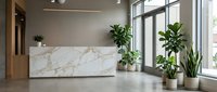 Modern office reception desk with white marble finish and green plants in contemporary workspace interior design for corporate business environment.