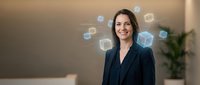 Professional businesswoman in dark suit smiling confidently with floating digital icons representing modern technology and communication in office environment.
