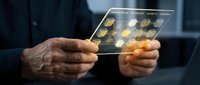 Businessman hands holding transparent digital tablet with glowing network icons displaying connectivity and data transfer in modern office environment.