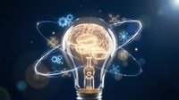 Creative lightbulb with glowing brain inside surrounded by orbiting gears and snowflakes on dark blue background for innovation and winter business concepts.