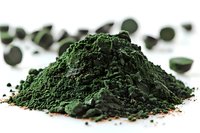 Organic spirulina powder heap with scattered tablets on white background, macro view of superfood supplement rich in protein and nutrients for healthy diet.