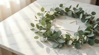 Eucalyptus wreath with blank card on marble table in soft sunlight, elegant botanical decor for wedding invitations and stationery.