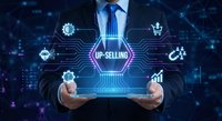 Businessman holding tablet with up-selling digital interface and connected business icons on futuristic network background for marketing strategy.