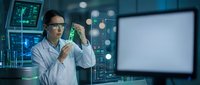 Asian male scientist in white lab coat examining test tube sample in modern research laboratory with computer monitors and advanced equipment.