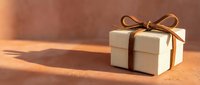 White gift box with brown ribbon bow on warm wooden surface with soft natural lighting creating elegant shadows for holiday celebrations and special occasions.