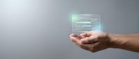 Male hand holding glowing digital interface with data lines and code elements, representing technology, software development, and digital innovation for business applications.