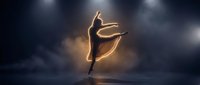 Professional ballet dancer performing graceful leap on dark stage with dramatic lighting and smoke effects for dance and performing arts concepts.