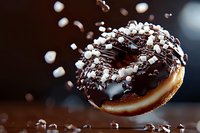 Chocolate glazed donut with mini marshmallows floating in air against dark background. Dynamic food photography with splash effect and rich details.
