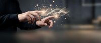 Person with hands cupped together releasing glowing golden particles and light sparks, symbolizing innovation, technology, creativity, and digital transformation in business.