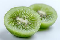 Fresh sliced kiwi fruit showing bright green flesh and white center core pattern on light background, macro close-up view highlighting natural texture and detail.