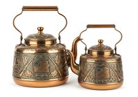 Pair of ornate brass teakettles with decorative etched patterns, wooden handles, and lids isolated on white background for kitchenware design projects.