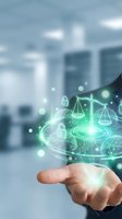 Businessman holding glowing digital hologram with justice scales and padlocks, symbolizing cybersecurity law and data protection compliance.