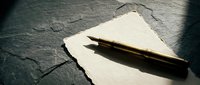 Vintage fountain pen resting on aged paper with dramatic lighting creates nostalgic writing atmosphere for literary projects and correspondence designs.