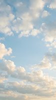 Soft pastel clouds drift across serene blue sky creating peaceful atmospheric background for meditation, wellness and tranquil nature scenes.