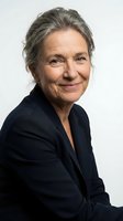 Mature woman with gray hair wearing dark navy blazer, smiling at camera against white background. Corporate portrait suitable for business websites, professional profiles, and executive headshots.
