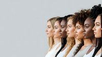 Diverse group of women in profile showing multicultural beauty and unity in professional business setting on neutral background.
