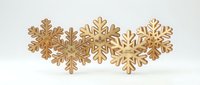 Golden wooden snowflakes arranged in decorative row on white background, isolated winter holiday ornaments for festive design and seasonal crafts.