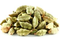 Heap of whole green cardamom pods isolated on white background, aromatic spice ingredient for cooking Asian and Indian cuisine, macro food photography.