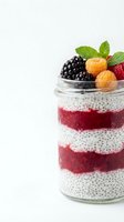 Layered chia pudding with fresh berries and mint in glass jar on white background for healthy breakfast and superfood recipes.