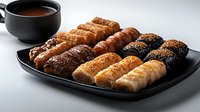 Assorted fresh baked pastries with different fillings and toppings served on black plate with dipping sauce, close up view on gray background. Food photography.