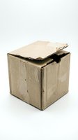 Damaged brown cardboard shipping box with torn edges and worn corners isolated on white background for packaging and delivery concepts.