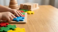 Child hands playing with colorful wooden puzzle pieces on natural wood table. Educational toys and learning activities for early childhood development.