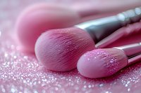 Pink makeup brushes with glitter sparkles on soft rosy background, professional cosmetic tools for beauty application and makeup artistry.