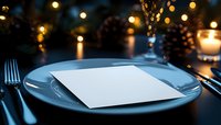 Empty white card on plate at romantic dinner setting with candlelight, bokeh lights and pine cones creating festive holiday atmosphere. Elegant table decor.