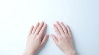 Two open hands with palms facing up on clean white background showing gesture of receiving, offering or presenting something for design projects.