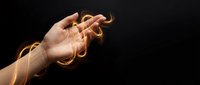 Hand reaching forward with glowing orange energy trails and light effects on dark background for digital art and fantasy design projects.
