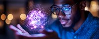 Young African American man in glasses holding glowing purple holographic sphere with network connections, illuminated by digital light in dark setting.