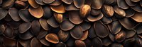 Roasted coffee beans in dark brown and copper tones create dramatic pattern. Natural arabica seeds macro photography shows rich texture and depth.