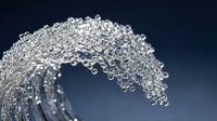 Crystal clear water splash frozen in motion creating elegant curved wave with droplets against dark blue background for refreshing beverage advertising.