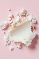 Torn white paper pieces creating abstract frame on pastel pink background. Artistic flat lay composition with ripped edges and soft shadows.