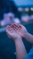 Open cupped hands in prayer gesture against blurred evening city lights background with purple and blue bokeh effects for spiritual and meditation concepts.