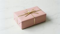 Pink gift box with golden ribbon bow on white background for special occasions and celebrations.