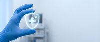 Young adult healthcare professional wearing blue latex glove holding digital medical cross icon with wireless connectivity symbol for telemedicine, digital health, and remote patient care services.