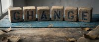 Wooden letter blocks spelling CHANGE on rustic table surface with natural lighting and weathered texture for motivational business concepts.